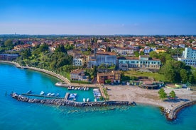 Photo of Old harbour Porto Vecchio with motor boats on turquoise water, green trees and traditional buildings in historical centre of Desenzano del Garda town, Northern Italy.