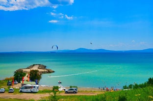 Photo of Saint Anastasia Island in Burgas bay, Black Sea, Bulgaria. Lighthouse tower and old wooden buildings on rocky coast.