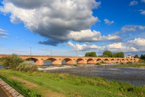 Photo of beautiful summer view of the arched bridge over the river Loire (Pont de Loire) in Nevers, France.