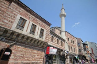 Touristic sightseeing ships in Golden Horn bay of Istanbul and mosque with Sultanahmet district against blue sky and clouds. Istanbul, Turkey during sunny summer day.