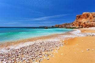 Photo of aerial view of beautiful lighthouse located on high cliffs of Saint Vincent cape in Sagres, Algarve, Portugal.