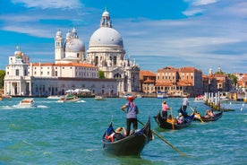 Famous buildings, gondolas and monuments by the Rialto Bridge of Venice on the Grand Canal, Italy.