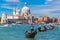 photo of Picturesque view of Gondolas on Canal Grande with Basilica di Santa Maria della Salute in the background, Venice, Italy. Selective focus on Gondolier .