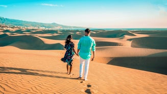 photo of landscape with Maspalomas town and golden sand dunes at sunrise, Gran Canaria, Canary Islands, Spain.