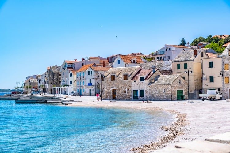 Photo of the old town and beautiful beach in Primosten town, Sibenik Knin County, Croatia.