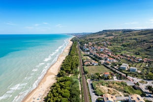 Photo of beach chairs, on a sandy, shoreline, in Giulianova, Italy.