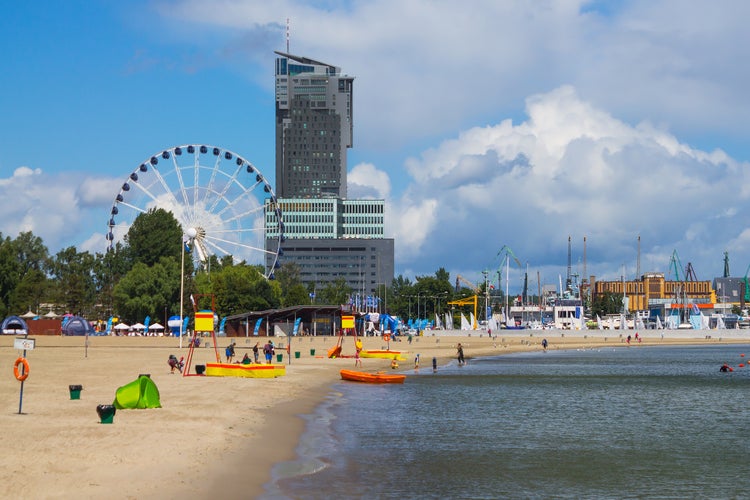 Photo of Water fountain in public park with view of tall tower building, Gdynia city waterfront, Poland