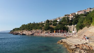 photo of  Pláž Senj it's a small beach hidden by vegetation near the Adriatic Sea, Senj, Croatia.