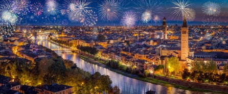 Photo of aerial view of Verona historical city centre, Ponte Pietra bridge across Adige river, Verona Cathedral, Duomo di Verona, red tiled roofs, Veneto Region, Italy.