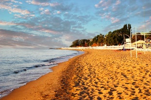 Photo of Saint Anastasia Island in Burgas bay, Black Sea, Bulgaria. Lighthouse tower and old wooden buildings on rocky coast.