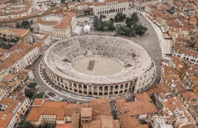 Photo of aerial view of Verona historical city centre, Ponte Pietra bridge across Adige river, Verona Cathedral, Duomo di Verona, red tiled roofs, Veneto Region, Italy.