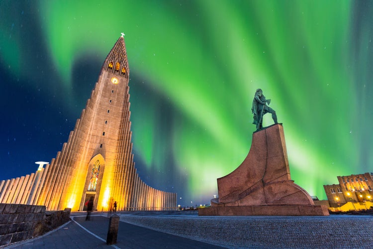 Photo of aurora borealis above hallgrimskirkja church in central of reykjavik city in Iceland.