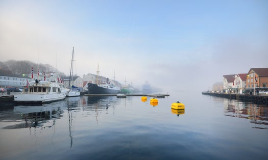 Old passenger ship and yachts moored to a pier in a city center. Stavanger embankment, Norway. Travel destinations, tourism, sightseeing, landmark, cruise, recreation, transportation, nautical vessel