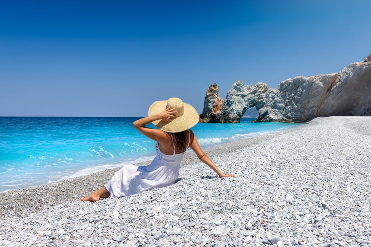 Photo of tourist woman enjoys the turquoise sea of Lalaria beach, Skiathos island, Greece