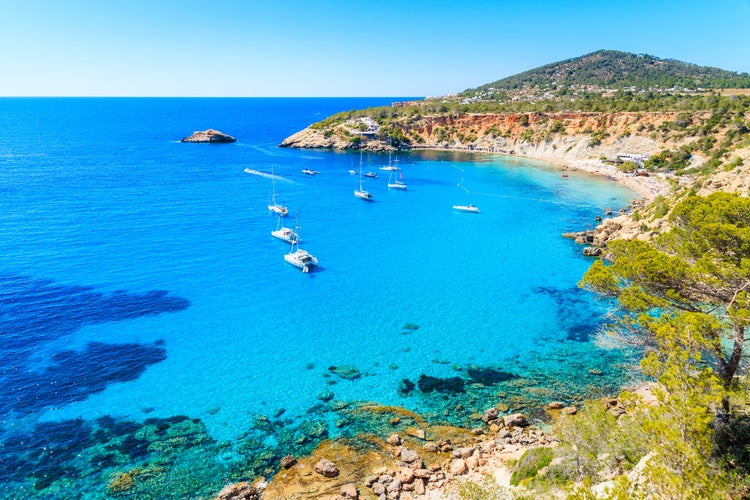 Sailing boats on Cala d'Hort bay with beautiful azure blue sea water, Ibiza island, Spain