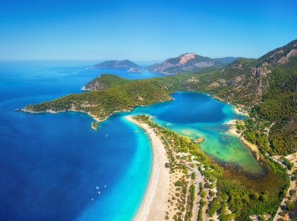 photo of amazing aerial view of Ölüdeniz-Kıdrak Nature Park, Turkey. Summer landscape with mountains, green forest, azure water, sandy beach and blue sky in bright sunny day.