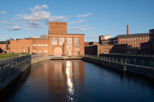 Aerial view of the Tampere city at sunset. Tampella building. View over Tammerkoski river in warm sunlight.