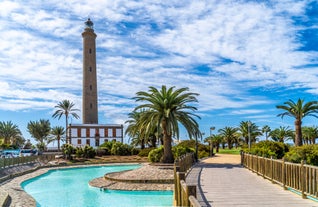 photo of landscape with Maspalomas town and golden sand dunes at sunrise, Gran Canaria, Canary Islands, Spain.