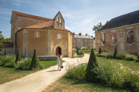 photo of a woman visiting the Baptistery of St. John (Baptistere Saint-Jean), which is a Roman Catholic church in Poitiers, France.