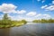 photo of landscape in the Netherlands with a wide creek in the Dutch national park De Biesbosch on a sunny and cloudy day in the spring season.