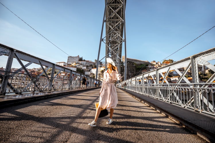 View on the famous Luis bridge with woman walking during the sunny day in Porto city, Portugal.jpg