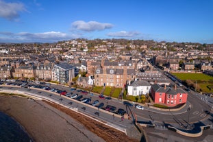 Photo of aerial view of Aberdeen as River Dee flows in a curve to the North Sea showing Duthie Park with bridge and traffic from south.