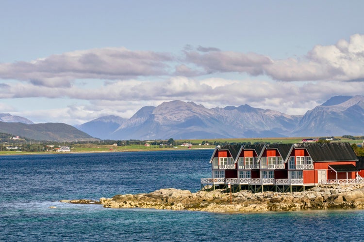 photo of view of Entrance from sea into fishing village of Stokmarknes, Norway, with mountains behind.