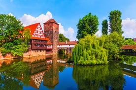 Photo of scenic summer view of the German traditional medieval half-timbered Old Town architecture and bridge over Pegnitz river in Nuremberg, Germany.