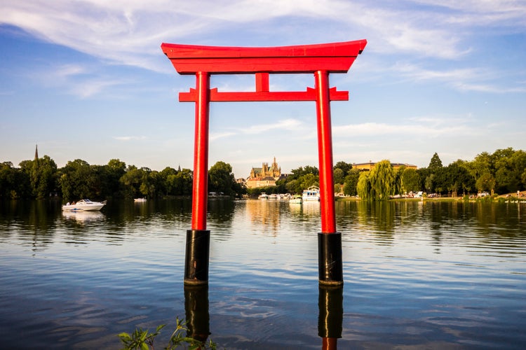 Photo of the Japanese torii in the Plan d'Eau Saint-Symphorien, Saulcy, Metz, France, with the Gothic cathedral of Saint Stephen in the background.