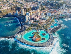 Photo of aerial view with Puerto de la Cruz, in background Teide volcano, Tenerife island, Spain.