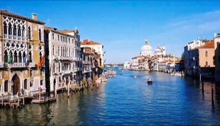 Famous buildings, gondolas and monuments by the Rialto Bridge of Venice on the Grand Canal, Italy.