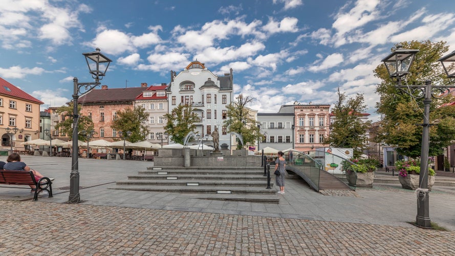 Panorama showing Neptune fountain on Old Town Market Square timelapse with historical houses around. Many cafes with umbrellas. Old town in Bielsko-Biala city, Poland