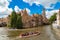 Photo of canal in Bruges and famous Belfry tower on the background in a beautiful summer day, Belgium.