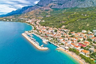 Photo of panorama and landscape of Makarska resort and its harbour with boats and blue sea water, Croatia.