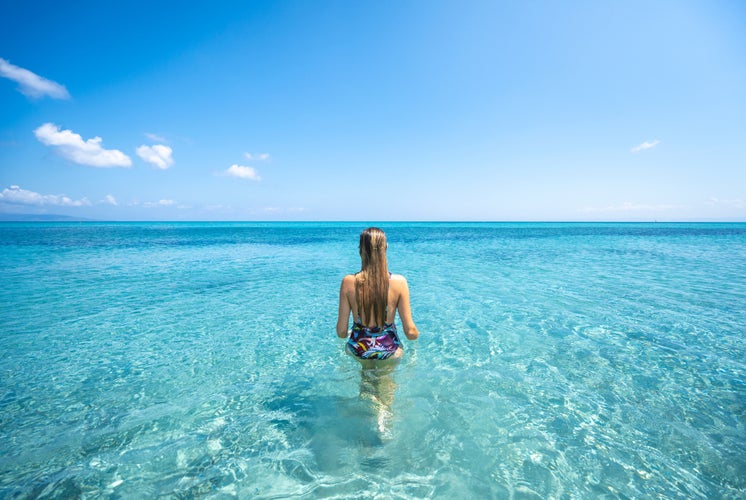 A girl walking in the water in La Pelosa beach, Sassari Province, Sardinia, Italy