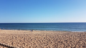 photo of an aerial view of wide sandy beach in touristic resorts of Quarteira and Vilamoura, Algarve, Portugal.