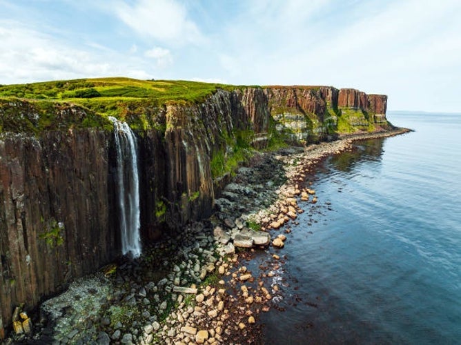 Kilt Rock and Mealt Falls on the Isle of Skye, Scotland, with the waterfall cascading from the distinctive kilt-like cliffs into the sea below.jpg