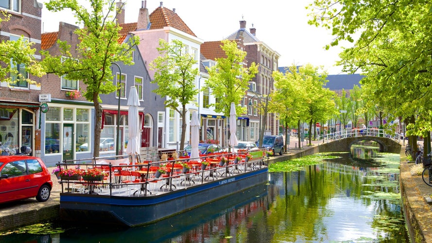 Picturesque Delft cityscape view with Eastern Gate Oostport and canal with cars and bicycles parked along. Delft, Netherlands's