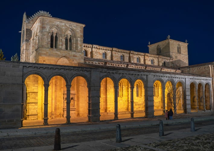 photo of view of Romanesque church of San Vicente illuminated at night in the capital of Avila.