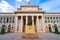 Photo of entrance to the Prado Museum in Madrid at this time, a sunny day with blue skies and clouds.