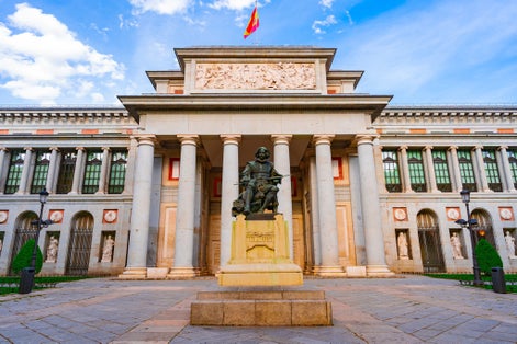 Photo of entrance to the Prado Museum in Madrid at this time, a sunny day with blue skies and clouds.