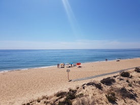 Photo of wide sandy beach in white city of Albufeira, Algarve, Portugal.