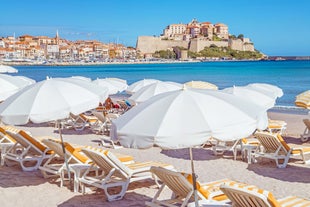 Photo of aerial view from the walls of the citadel of Calvi on the old town with historic buildings and bay with yachts and boats, Corsica, France.