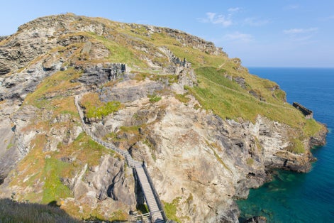 Photo of aerial view of Tintagel Castle a Norman fortification located on the peninsula of Tintagel Island, adjacent to the village of Tintagel in Cornwall, England.