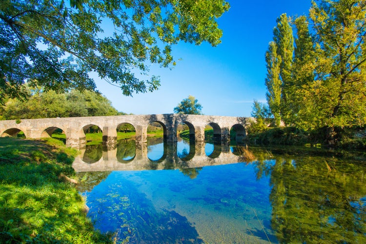 photo of view of Croatian countryside, old stone bridge over the Dobra river in Novigrad, Karlovac county, beautiful landscape