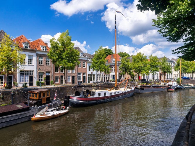 The old harbor in Den Bosch,North Brabant ,the Netherlands, with boats anchored at the quay and medieval houses on a summer day