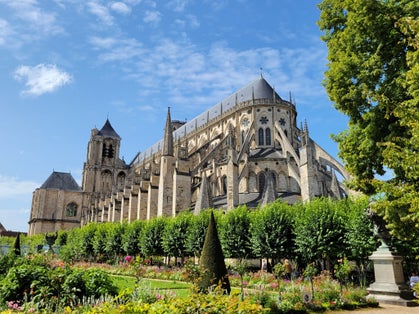 Photo of Cathedral in Nevers, France against beautiful blue sky with botanical garden in foreground.