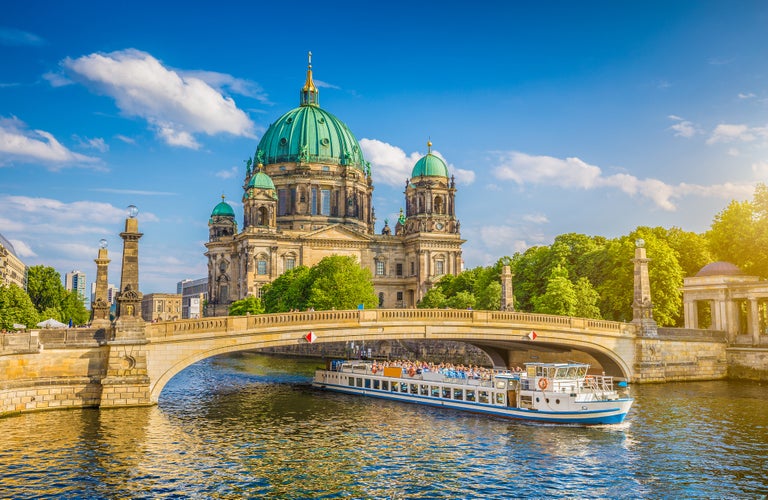 beautiful view of historic Berlin Cathedral (Berliner Dom) at famous Museumsinsel (Museum Island) with excursion boat on Spree river in beautiful sunset in summer, Berlin.