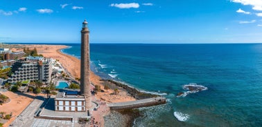 photo of landscape with Maspalomas town and golden sand dunes at sunrise, Gran Canaria, Canary Islands, Spain.