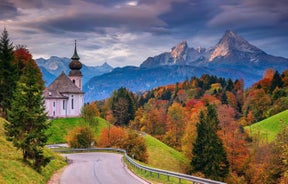 photo of historic town of Berchtesgaden with famous Watzmann mountain in the background on a sunny day with blue sky and clouds in springtime, National Park Berchtesgaden Land, Upper Bavaria, Germany.